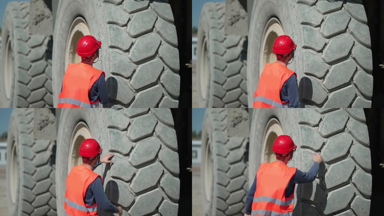 工程师在每天从露天矿开始矿石运输前检查自卸车轮胎的质量，慢动作