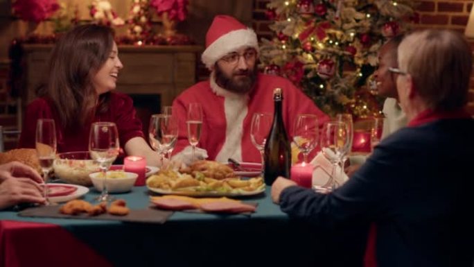 有趣的人装扮成圣诞老人在圣诞晚宴上与家人谈论礼物