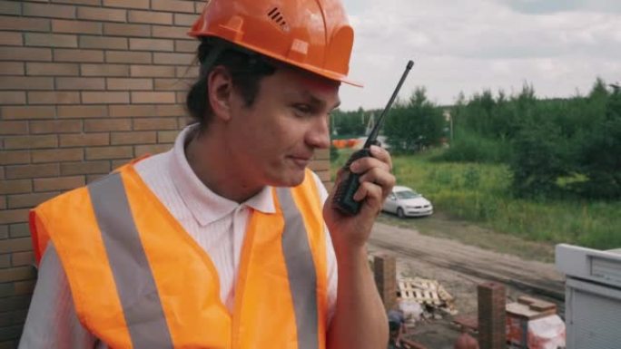 工头或安全帽检查员在建筑工地与对讲机交谈
