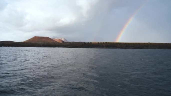雨后和恶劣天气后，在特内里费岛加那利岛上的一条令人难以置信的美丽彩虹上，从豪华游艇上观看。去任何地方