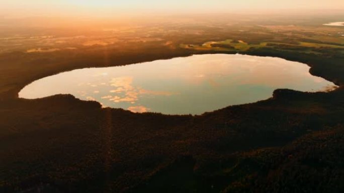 日落时的森林湖，空中无人机拍摄。鸟瞰野生动物湖中的日落。