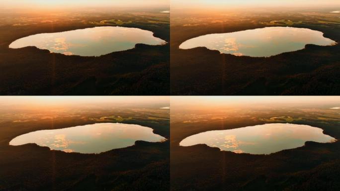日落时的森林湖，空中无人机拍摄。鸟瞰野生动物湖中的日落。