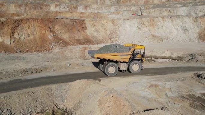 一辆采矿卡车的鸟瞰图正在驾驶一个装有矿石的铁矿。