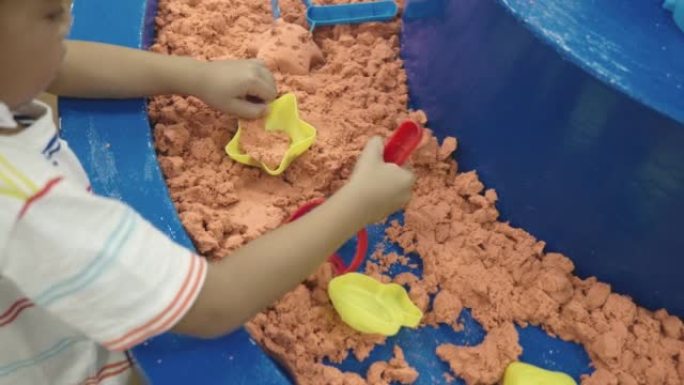 快乐的亚洲儿童在娱乐中心玩耍充气城堡在检疫玩动感沙