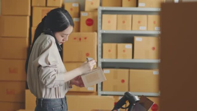 Asian woman working at online store warehouse usin