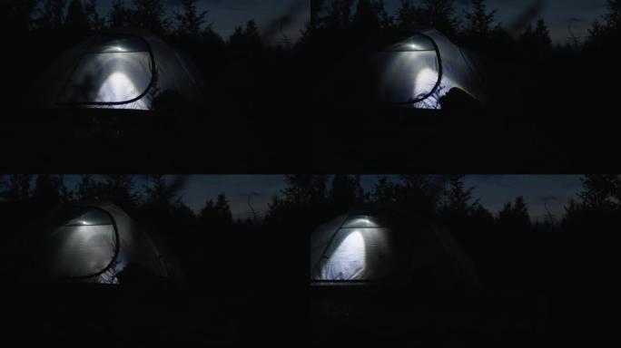 手电筒在夜间帐篷里发光。帐篷里的夜灯。旅游帐篷，过夜山