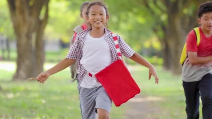 快乐的小学生在学校跑步。回到学校