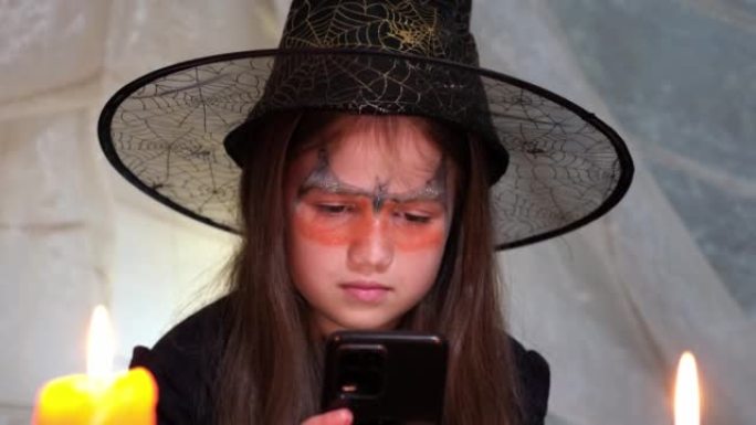 小女巫在手机上上网搜索万圣节夜魔咒