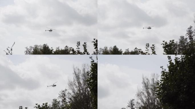 民用直升机在天空中飞行，在树梢上空低空艰难转弯。