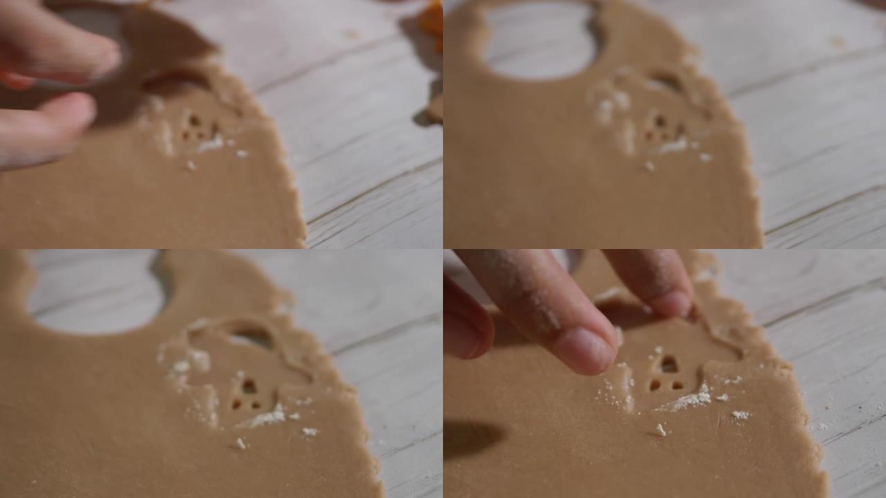 儿童的手使用饼干切割器成型自制饼干，庆祝万圣节，生活方式的概念。