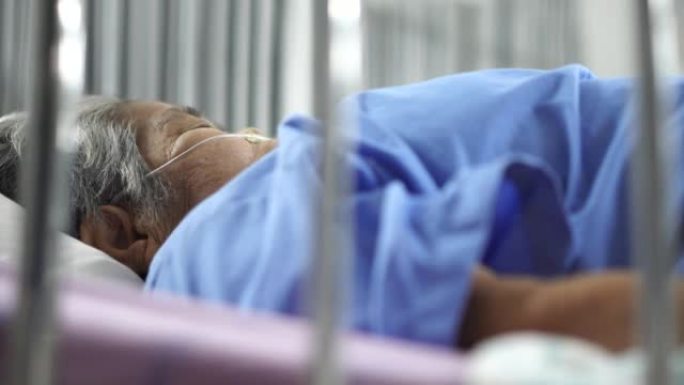 一名老年妇女在医院的病床上生病。