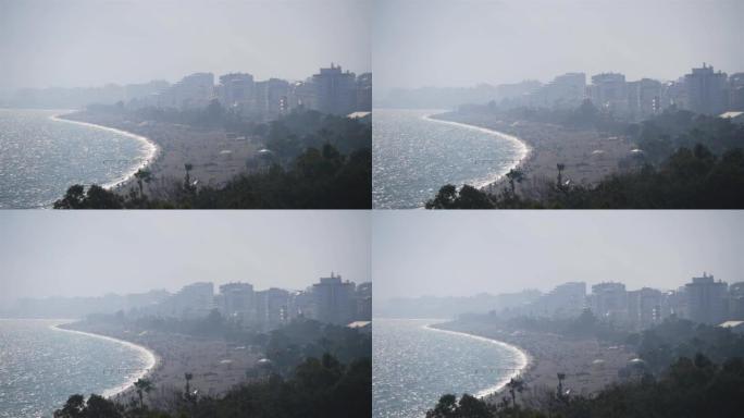 海滨薄雾中的大城市的景色，许多人在大海滩上