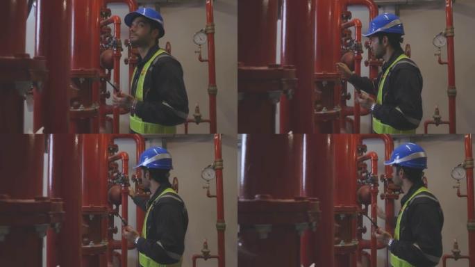 工程师正在检查行业冷冻水风机盘管机组空调是大型工业建筑的水冷却塔空气冷却器暖通系统控制空气系统