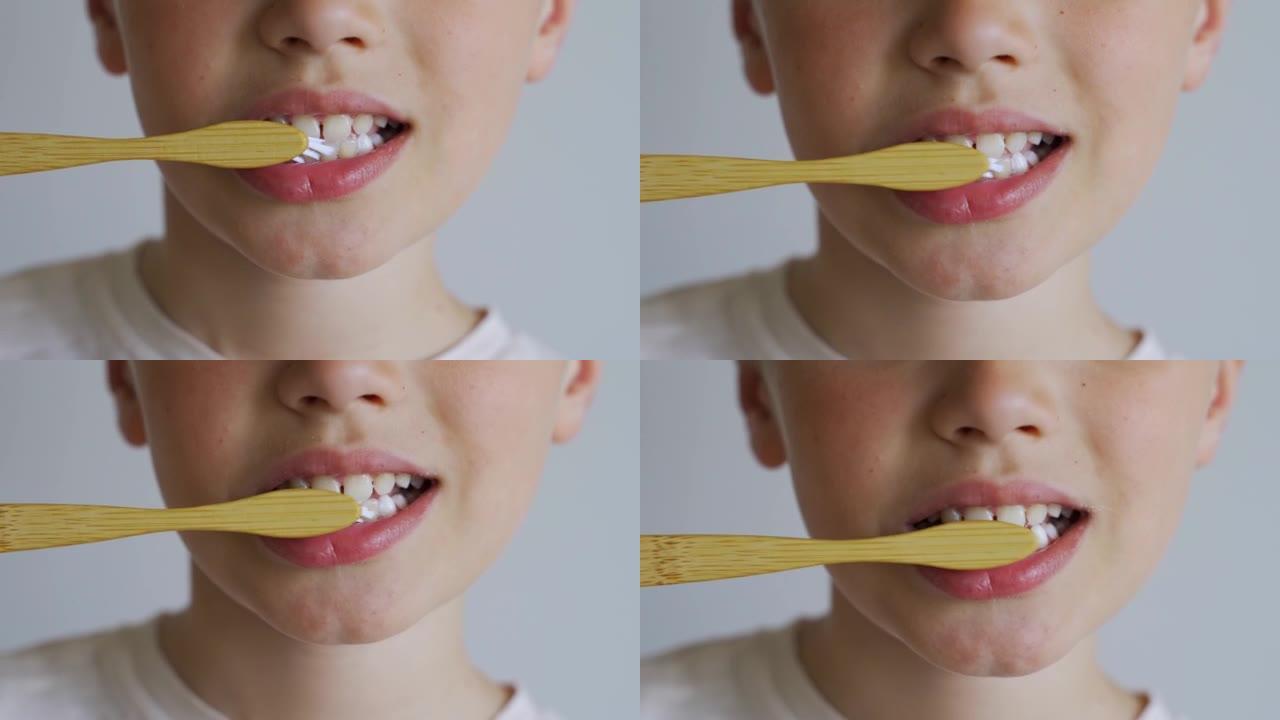 用白色背景上的eco木制牙刷关闭儿童刷牙。儿童的牙齿卫生，早晨常规，健康的生活方式，医疗保健。