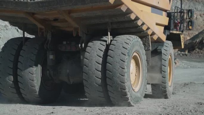 操作员在金矿场驾驶重型自卸车采矿设备，慢动作