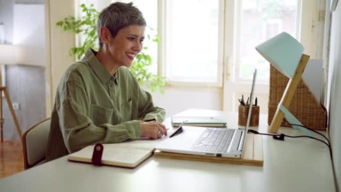 女商人在家中使用笔记本电脑进行视频通话