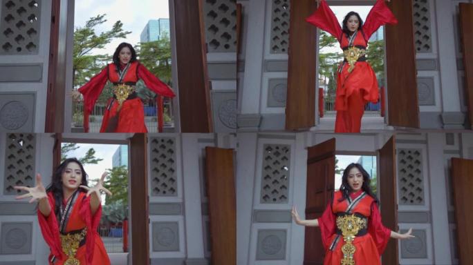 一名亚洲女子穿着中国红连衣裙时全力以赴跳舞