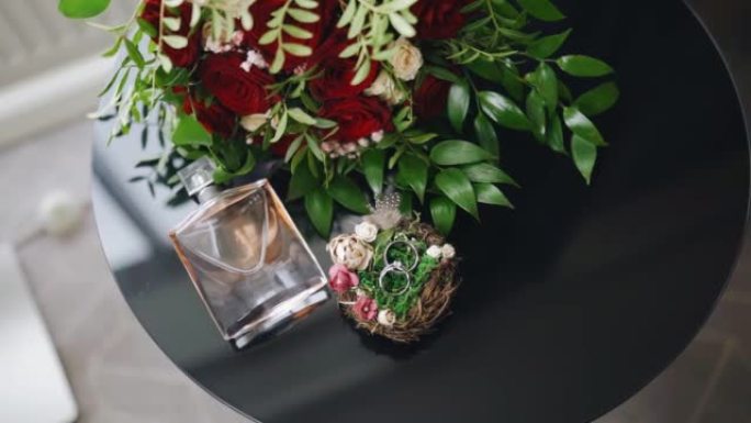 桌子上是香水，花朵和金戒指的组成。从上方查看对象