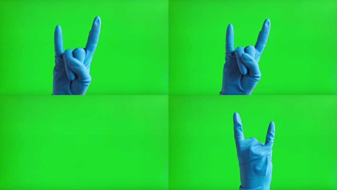 戴上医用手套，手势岩石图标隔离在绿色屏幕背景上。特写。人用蓝色手套在色度键屏幕上做摇滚手势。4k镜头