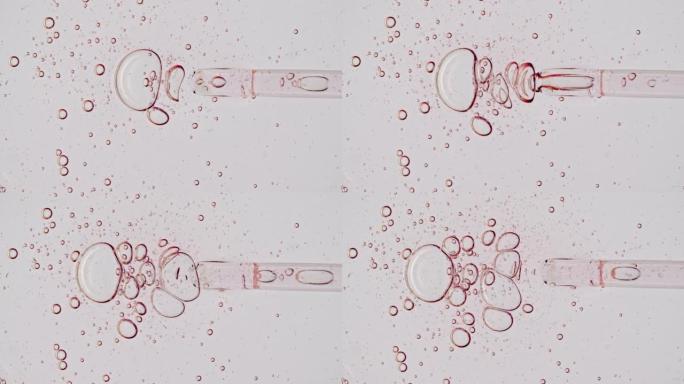 透明的粉红色化妆品凝胶液，带有分子气泡的血清油在移液器中滴落在白色背景上。天然有机化妆品、药物的宏观