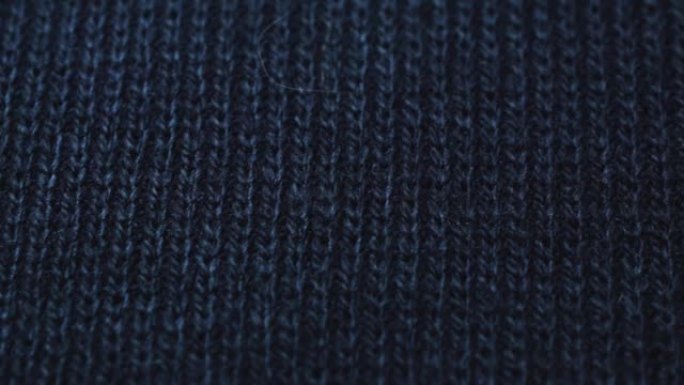 深蓝色针织面料质地。特写细节毛衣面料背景。冬季时尚背景柔软羊毛纺织图案