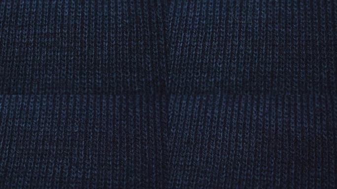 深蓝色针织面料质地。特写细节毛衣面料背景。冬季时尚背景柔软羊毛纺织图案