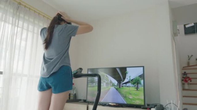 年轻女子在健身房锻炼时使用虚拟现实进行虚拟跑步