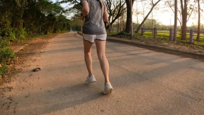 Rear view of Asian woman jogging on the street in 