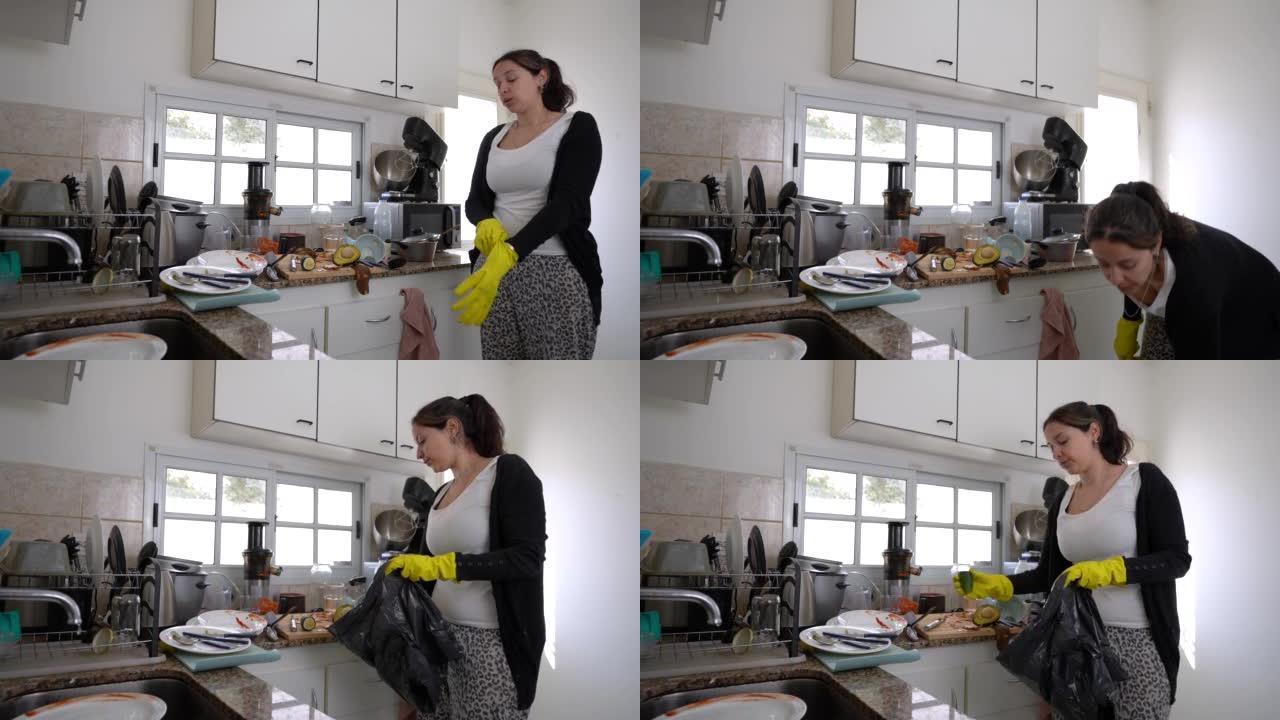 年轻女子戴上清洁手套清洁肮脏的厨房