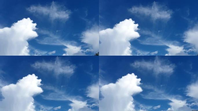 蓝色的夏天多云的天空，喷射的轨迹蒸气小径在很远的地方