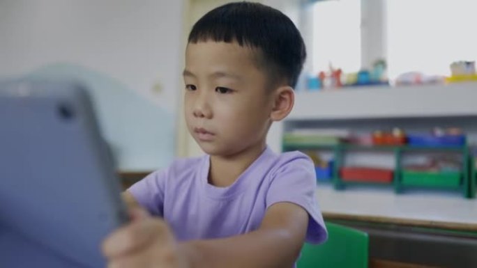亚洲小男孩使用数字平板电脑进行互动