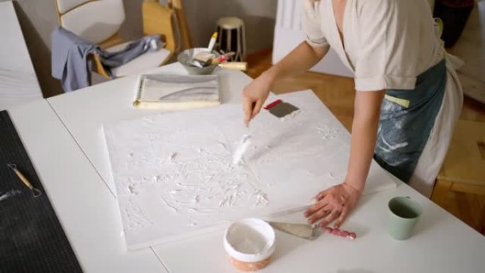 面目全非的女艺术家用尖刻的腻子和抹子在画布上创作艺术