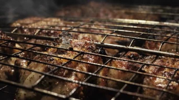 户外烧烤野餐烹饪过程，烧烤和烧烤多汁的肉排，烧烤架上燃烧的火和烟，燃烧的煤。烧烤概念。