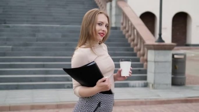 Business woman walking with documents and cup of t