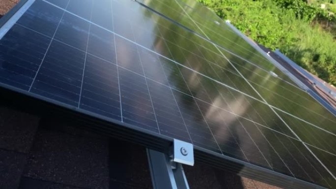 光伏太阳能电池板在小型房屋沥青瓦屋顶上的安装过程。清洁绿色可再生能源DIY