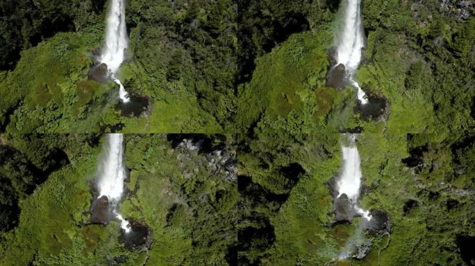 无人驾驶飞机拍摄了El salt El Leon的瀑布，周围是植被，并用彩虹鹤射击