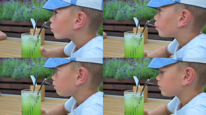 小男孩在餐馆里用吸管喝果汁。4k视频镜头UHD 3840x2160