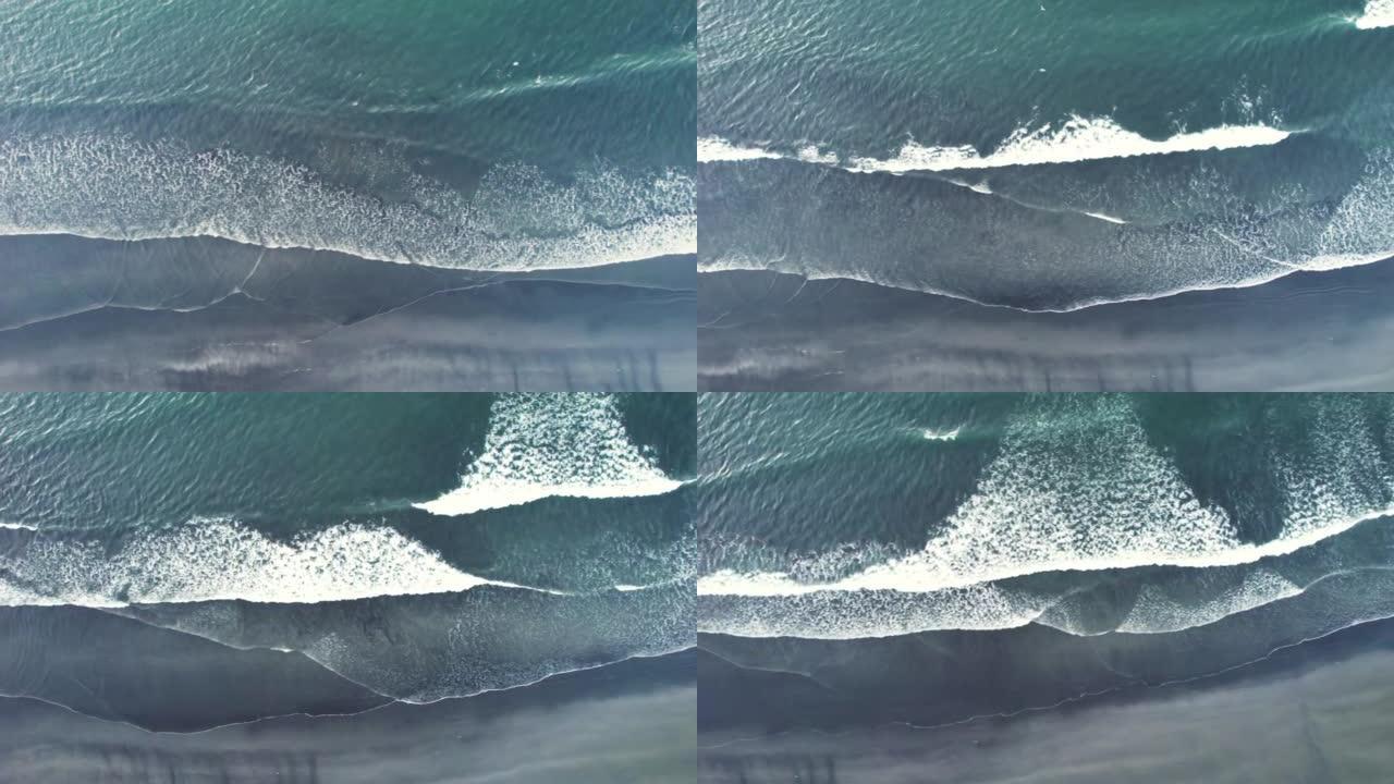 夏季海浪和黑沙滩的鸟瞰图