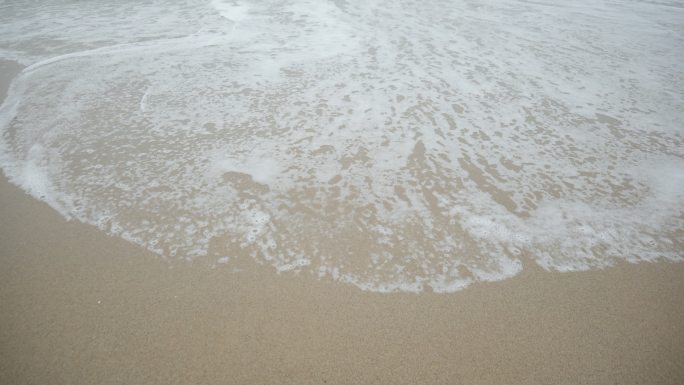 海浪泡沫拂过金色海滩