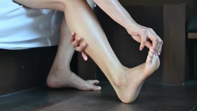 女人试图伸展和按摩她的腿，以缓解晚上腿抽筋的疼痛。