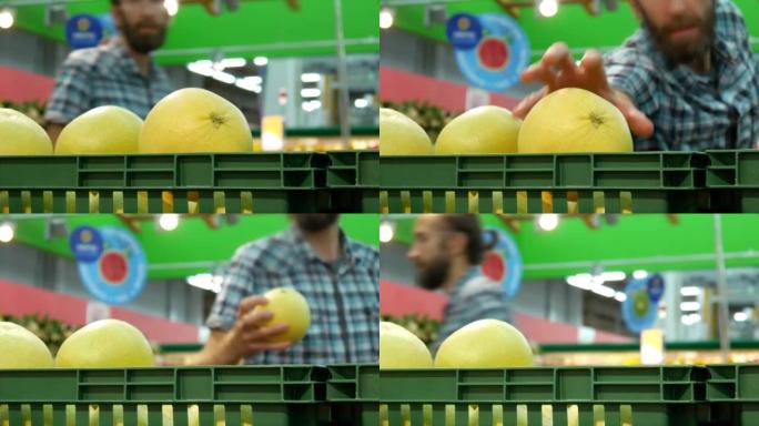 交易篮子中成熟柚子的特写镜头，一名男性买家拿走了一个