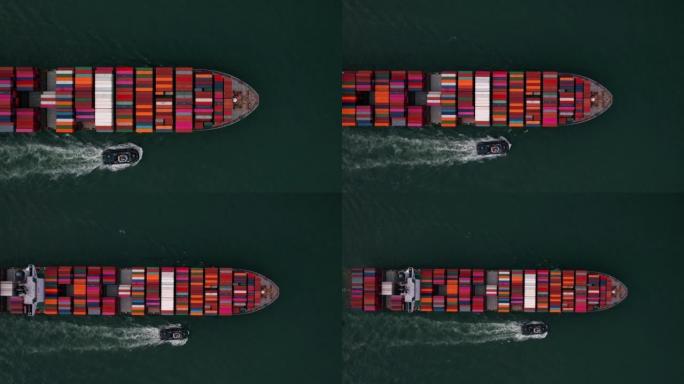 Aerial top view cargo container ship with contrail