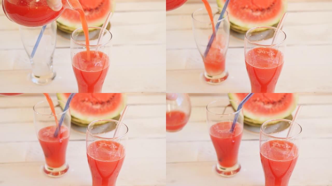 将西瓜果肉中的新鲜红色饮料倒入两个玻璃玻璃杯中，玻璃杯中装有冰块和玻璃可重复使用的吸管，以供饮用。特