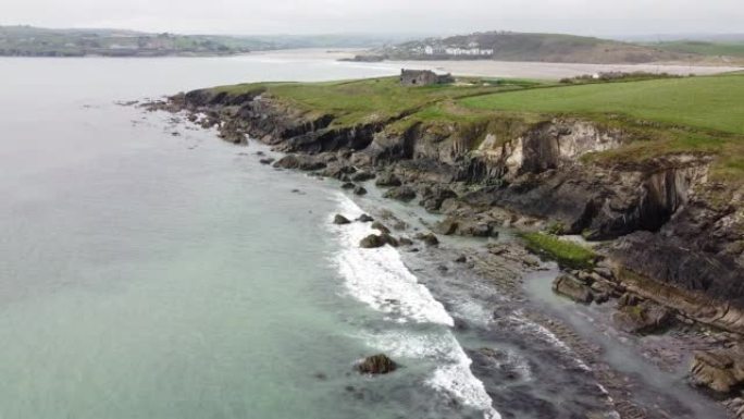 爱尔兰岩石海岸上的绿色田野。凯尔特海的水域触礁。海滨，风景。