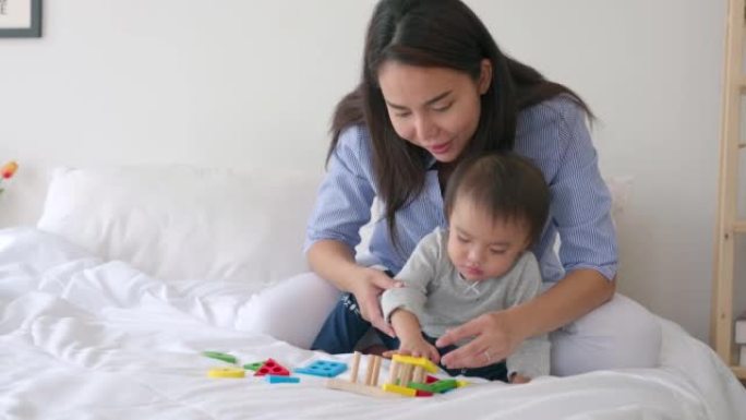Mother teaching daughter to playing with toy for p
