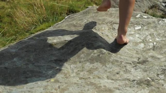 女人赤脚踩着石头。