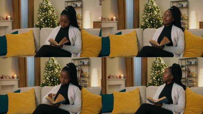 一个非洲女孩坐在沙发上，拿着蓝色封面的书看书。看完这一节后，女孩想了想，梦dream以求地看着窗外。