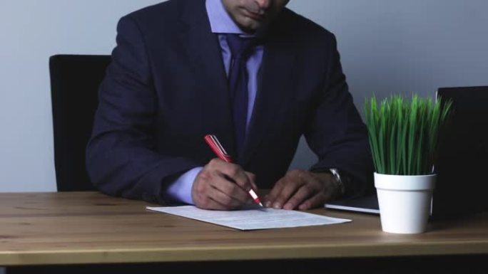 公证人在用钢笔成功达成协议后签署合同。一位穿着正装的专注年轻商人的特写镜头仔细阅读合同条款。董事批准