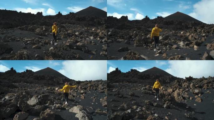 女旅行者在特内里费岛泰德国家公园的钦耶罗火山周围的熔岩田野中漫步。去任何地方。另一个星球的表面。慢动