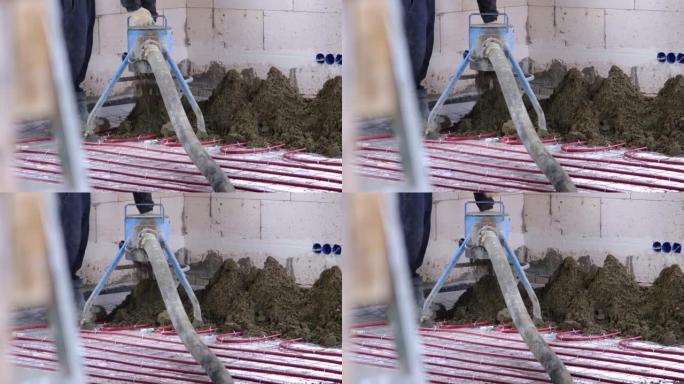 半干地板熨平板 -- 一名工人通过一个特殊的套筒铲出建筑混合物，用于在地板下加热管上固井和找平。慢动